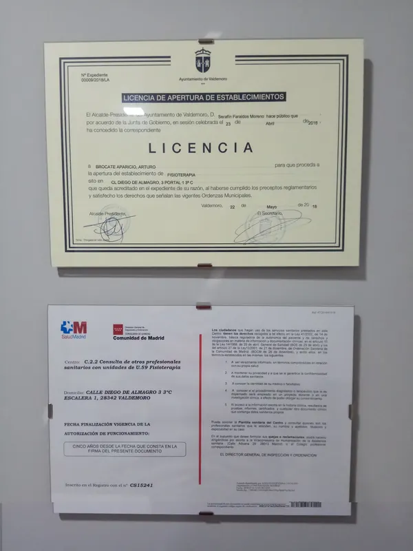 La licencia de apertura del Ayuntamiento de Valdemoro y la autorización sanitaria de la Comunidad de Madrid, enmarcadas en la pared de la consulta